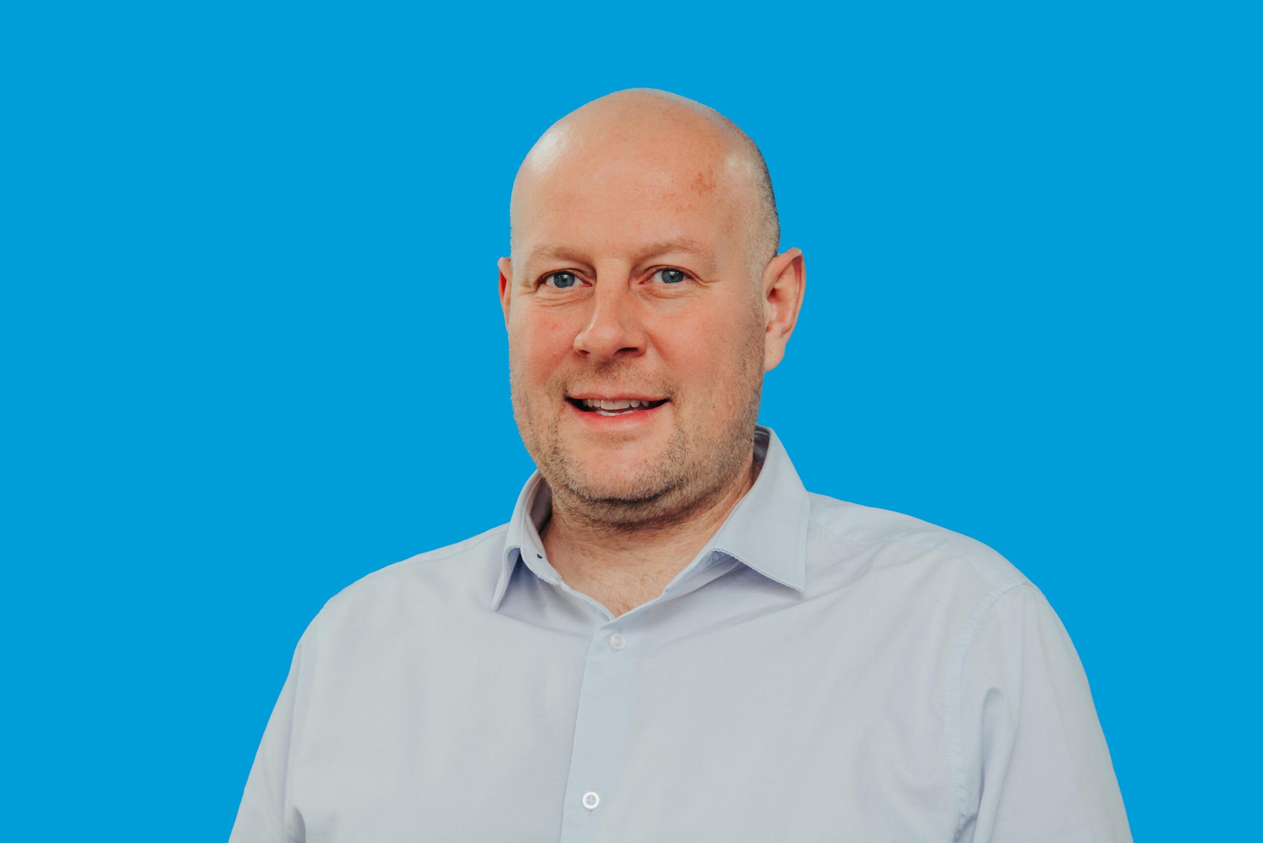 Photo of Richard Farrell against a blue background